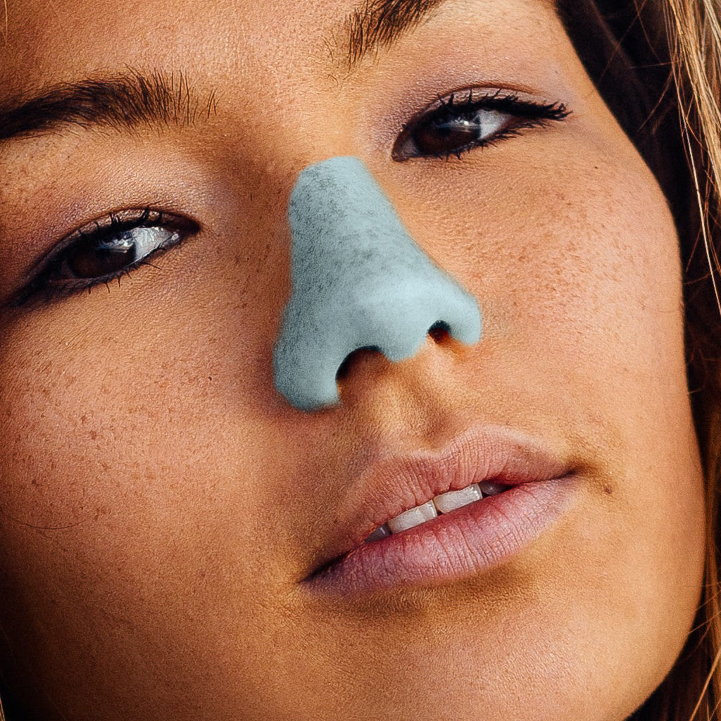 brunette girl with blue noz vegan nose sunscreen on nose